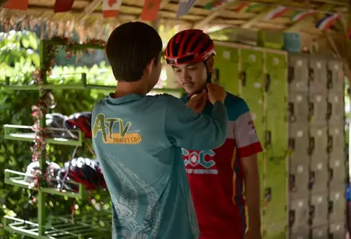 ATV instructor checking a rider’s helmet for safety at Phuket ATV Adventure, by Phuket Travel Store