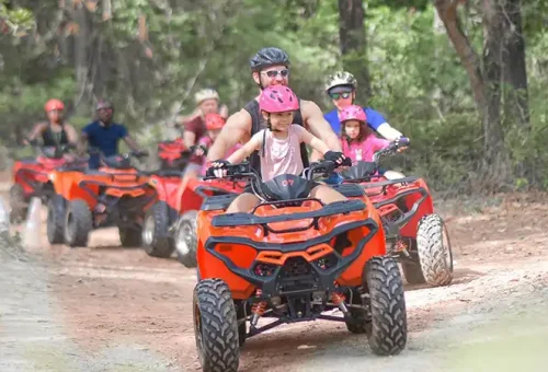 Father and daughter riding an ATV together at Phuket ATV Adventure, available through Phuket Travel Store