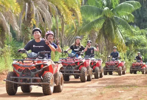 Smiling ATV riders after completing their ride at Phuket ATV Adventure, offered by Phuket Travel Store