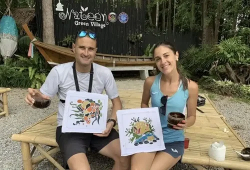 Tour guide presenting a small souvenir to a smiling customer at the end of the Koh Yao Noi cycling tour with Phuket Travel Store
