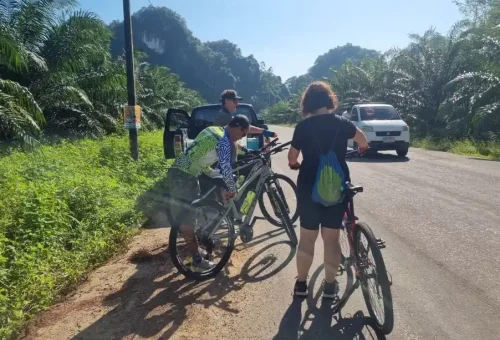 Biking guide assisting a customer with their bicycle during the Koh Yao Noi cycling tour organized by Phuket Travel Store