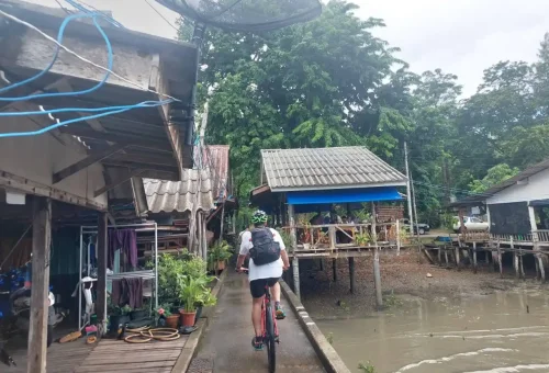 Cyclist taking a peaceful break at a scenic pier on Koh Yao Noi, with panoramic views of the sea and nearby islands.