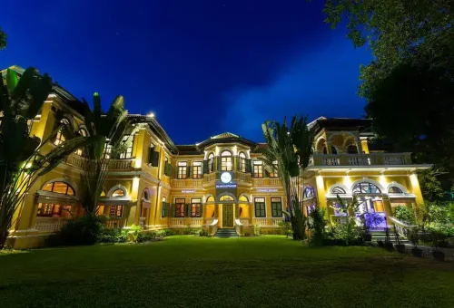 Exterior view of the historic Blue Elephant Cooking School building in Phuket, featuring elegant colonial architecture and lush tropical surroundings.