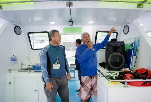 Tour guide explaining the twilight sea canoe itinerary to guests on board the boat in Phang Nga Bay