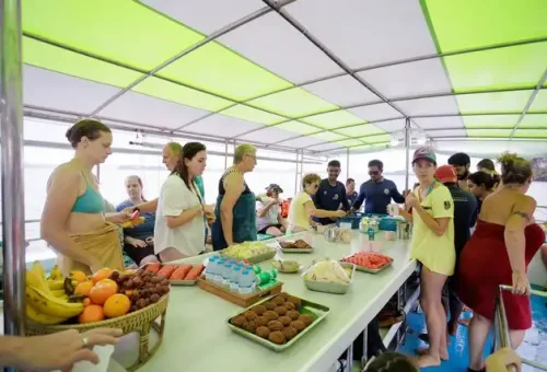 Guests enjoying lunch together on board the boat during the twilight sea canoe tour in Phang Nga Bay