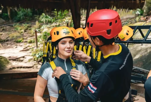 Thrill-seekers of all ages enjoying a high-speed zipline ride through the lush jungle at Flying Hanuman in Phuket