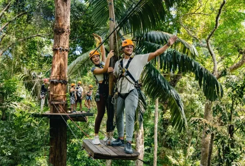 Smiling couple and family enjoying a zipline experience together at Flying Hanuman in Phuket, surrounded by lush jungle