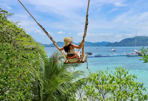 Wooden swing facing the turquoise sea at Banana Beach, Coral Island, offering a peaceful spot with panoramic ocean views