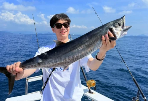 Please create a image alternative and caption text for image optimized for mobile or social platform ofgame-fishing-and-trolling-phuket-travel-store-14 happy customer presents proud their fish catches on fishing boat