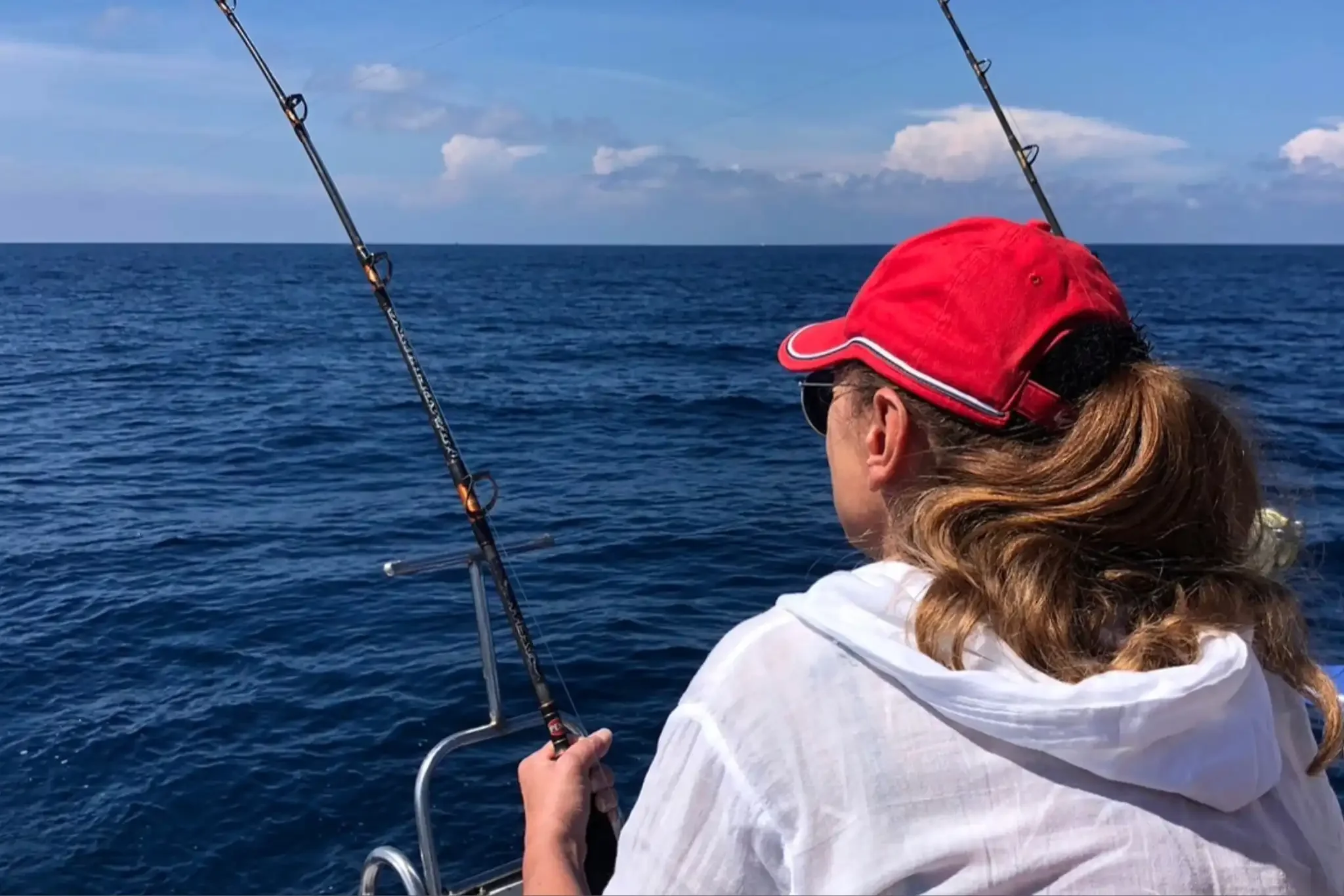 Group of happy customers actively fishing on a game fishing and trolling boat off the coast of Phuket, enjoying the ocean adventure