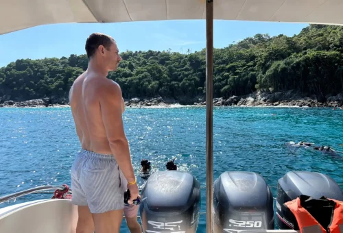Tourists snorkeling directly from a speedboat in the clear blue waters near Kahung Beach, Coral Island