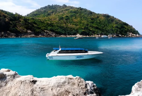 Speedboat cruising to Raya Island with clear blue skies and turquoise waters – Phuket Travel Store adventure.