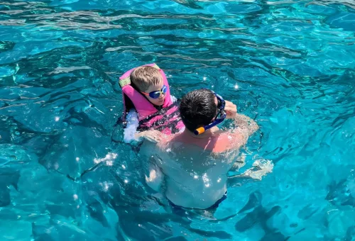 Happy traveler on a speedboat to Raya Island, equipped with snorkel gear and ready for an ocean adventure with Phuket Travel Store.