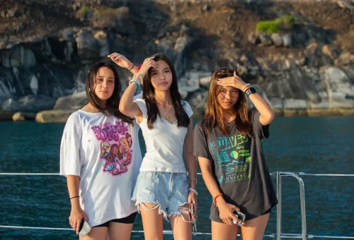 Beautiful girls enjoying the sunset on a sailing cruise near Promthep Cape, Phuket.