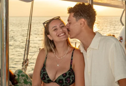 Romantic couple enjoying a sunset sailing cruise near Coral Island and Promthep Cape.