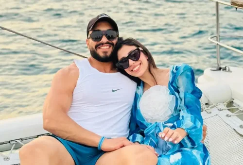 Romantic couple embracing on the deck of a sunset sailing cruise near Coral Island and Promthep Cape.
