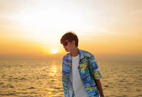 Guests watching a breathtaking sunset from the deck of a sailing yacht near Coral Island and Promthep Cape.