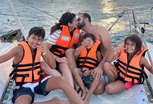 A large joyful family smiling and enjoying their time together on a sailing yacht cruise near Coral Island and Promthep Cape.