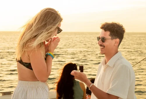 Romantic sunset proposal with "Will you marry me?" sign held on a sailing yacht near Coral Island and Promthep Cape.