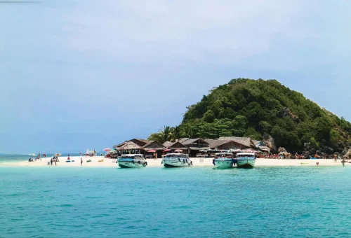 Scenic view of Khai Nok Island with white sand beach, clear blue sea, and tropical surroundings, taken during the Phi Phi Island speed catamaran tour by Phuket Travel Store