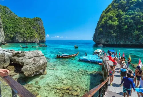 Losama Bay at Phi Phi Leh Island with emerald-green water, dramatic limestone cliffs, and lush vegetation, featured on the Phi Phi Island speed catamaran tour by Phuket Travel Store