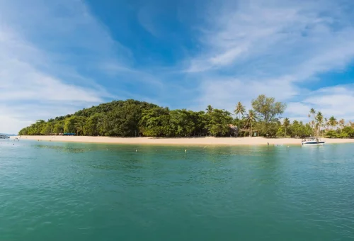 Aerial view of Rang Yai Island with lush greenery, long white sandy beach, and turquoise waters, featured on the James Bond Island tour by Phuket Travel Store