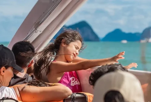 Children smiling and enjoying the catamaran ride during the James Bond Island tour, with sea views and open-air seating