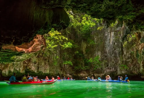 Canoeing group exploring the emerald lagoon at Hong Island, surrounded by limestone cliffs, part of the James Bond Island tour by Phuket Travel Store