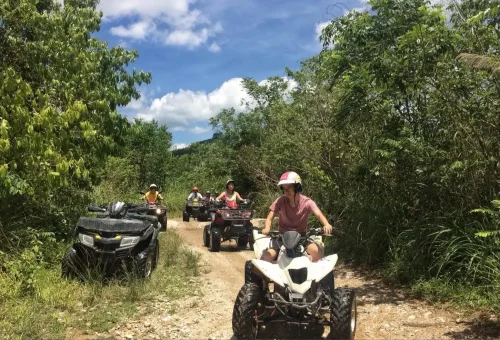 ATV rider splashing through a muddy jungle trail in Phang Nga with Anda Adventure – PhuketTravelStore.com
