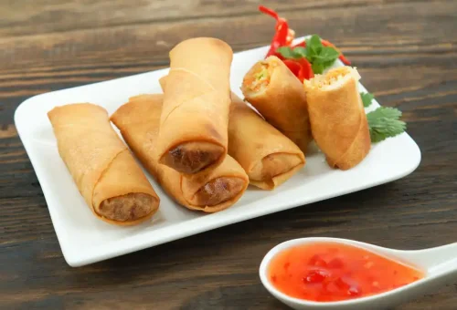 Crispy Thai Spring Rolls from Kata Thai Cooking Class in Phuket – golden-fried rolls filled with vegetables and served with sweet chili sauce.