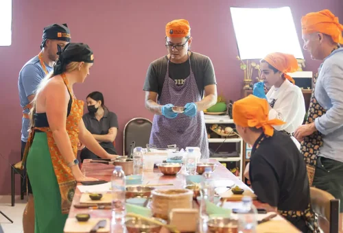 Thai chef explaining traditional cooking techniques at Kata Thai Cooking Class in Phuket
