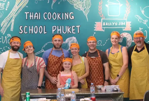 Group of happy customers posing after Thai cooking session at Kata Thai Cooking Class in Phuket