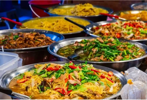 Assorted colorful Thai street food dishes displayed at a local market in Phuket Town, featured during the street food tour with Phuket Travel Store