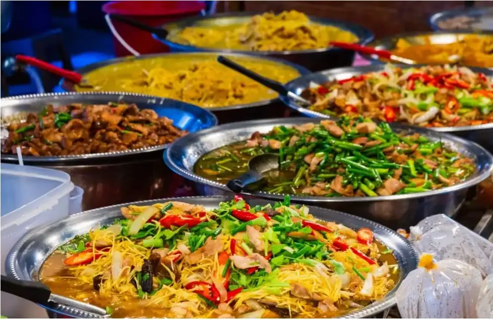 Assorted colorful Thai street food dishes displayed at a local market in Phuket Town, featured during the street food tour with Phuket Travel Store