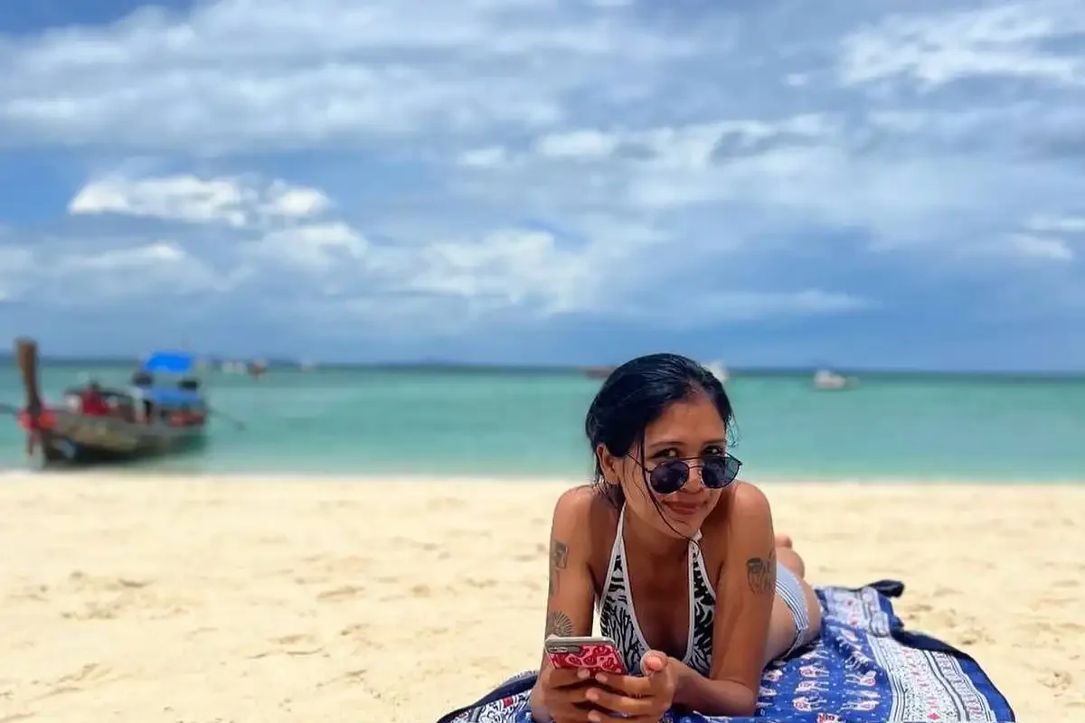 Happy guests relaxing and enjoying the sunny beach at Khai Nok Island, Phuket