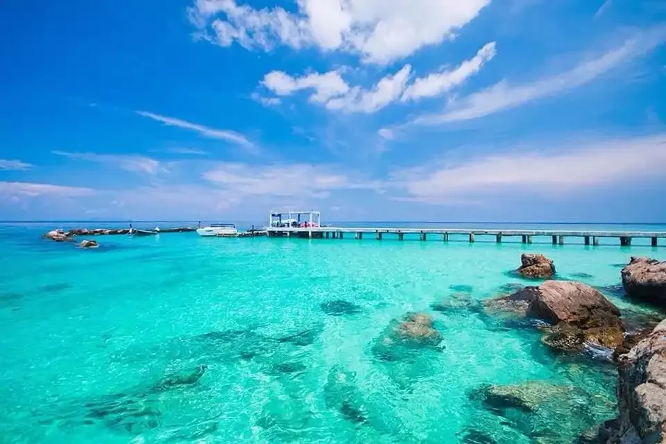 Stunning view of the wooden pier stretching over turquoise waters at Maiton Island, surrounded by tropical scenery