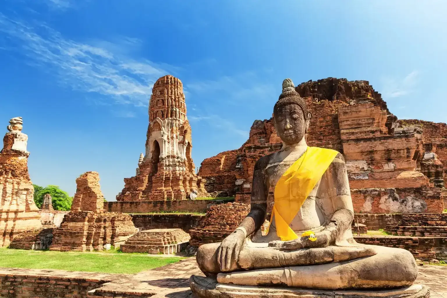 Ancient Buddha statue and temple ruins at Ayutthaya Historical Park, Thailand – a must-visit heritage site with Phuket Travel Store