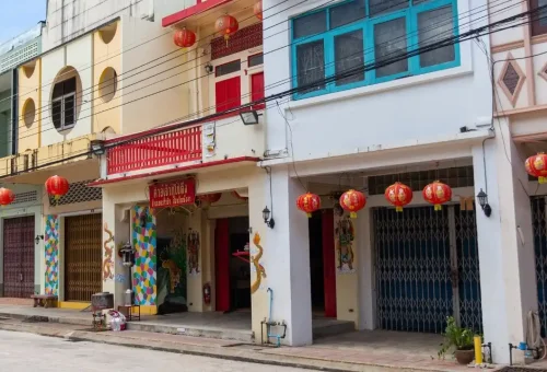 Street scene in Old Town Takuapa showcasing preserved colonial-style buildings, local Thai signage, and everyday village life.