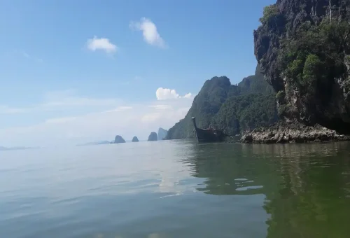 Tourist canoeing through limestone caves and lagoons at Panak Island in Phang Nga Bay, Thailand