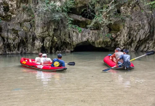 Visitors canoeing through calm waters and limestone formations at Hong Island in Phang Nga Bay
