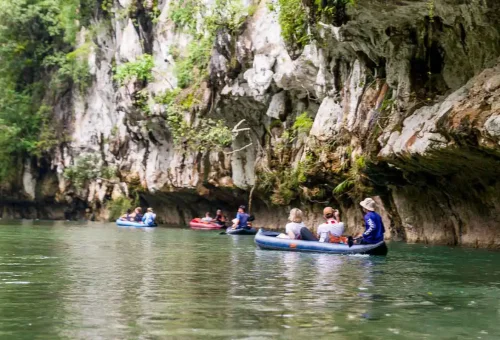 Canoe gliding on the calm Sok River in Khao Sok National Park – surrounded by lush jungle and towering limestone karsts