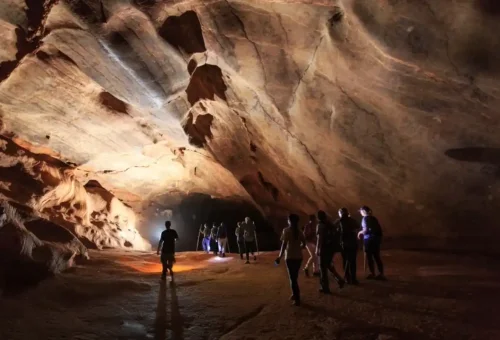 Adventurous traveler exploring a limestone cave surrounded by jungle in Khao Sok National Park