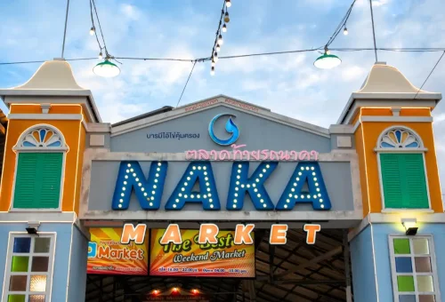 Locals and tourists walking through Naka Market with vibrant lighting