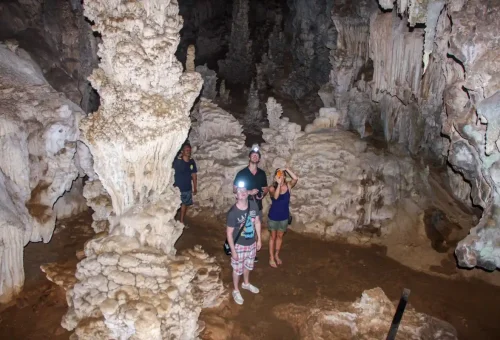 Traveler exploring a limestone cave near Cheow Lan Lake in Khao Sok National Park