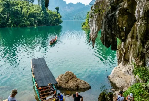 View of a limestone cave entrance from a longtail boat on Cheow Lan Lake in Khao Sok National Park