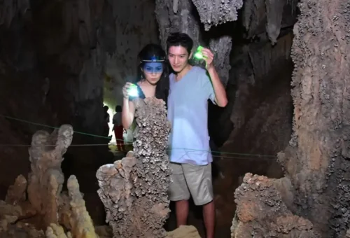 Tourist exploring a cave near Cheow Lan Lake inside Khao Sok National Park on a two-day wildlife tour with Phuket Travel Store