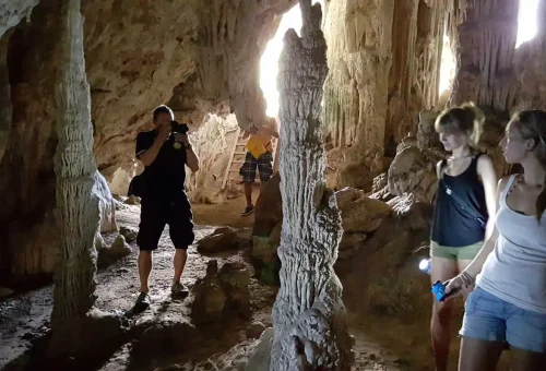 Traveler exploring a limestone cave at Khao Sok National Park with Phuket Travel Store.