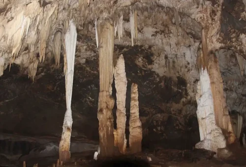 Guest walking through a mysterious cave chamber in Khao Sok National Park with Phuket Travel Store.