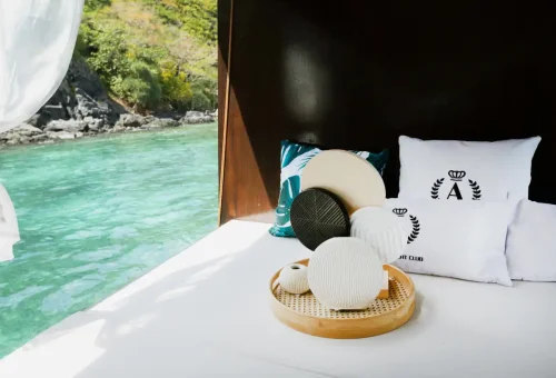 Premium wooden longtail boat with plush seating and happy travelers in Phuket