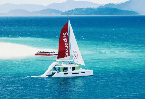 Aerial view of Super-X private yacht charter gliding through turquoise waters in Phuket